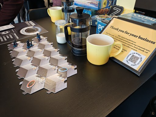 French press coffee and a game in play at a café table